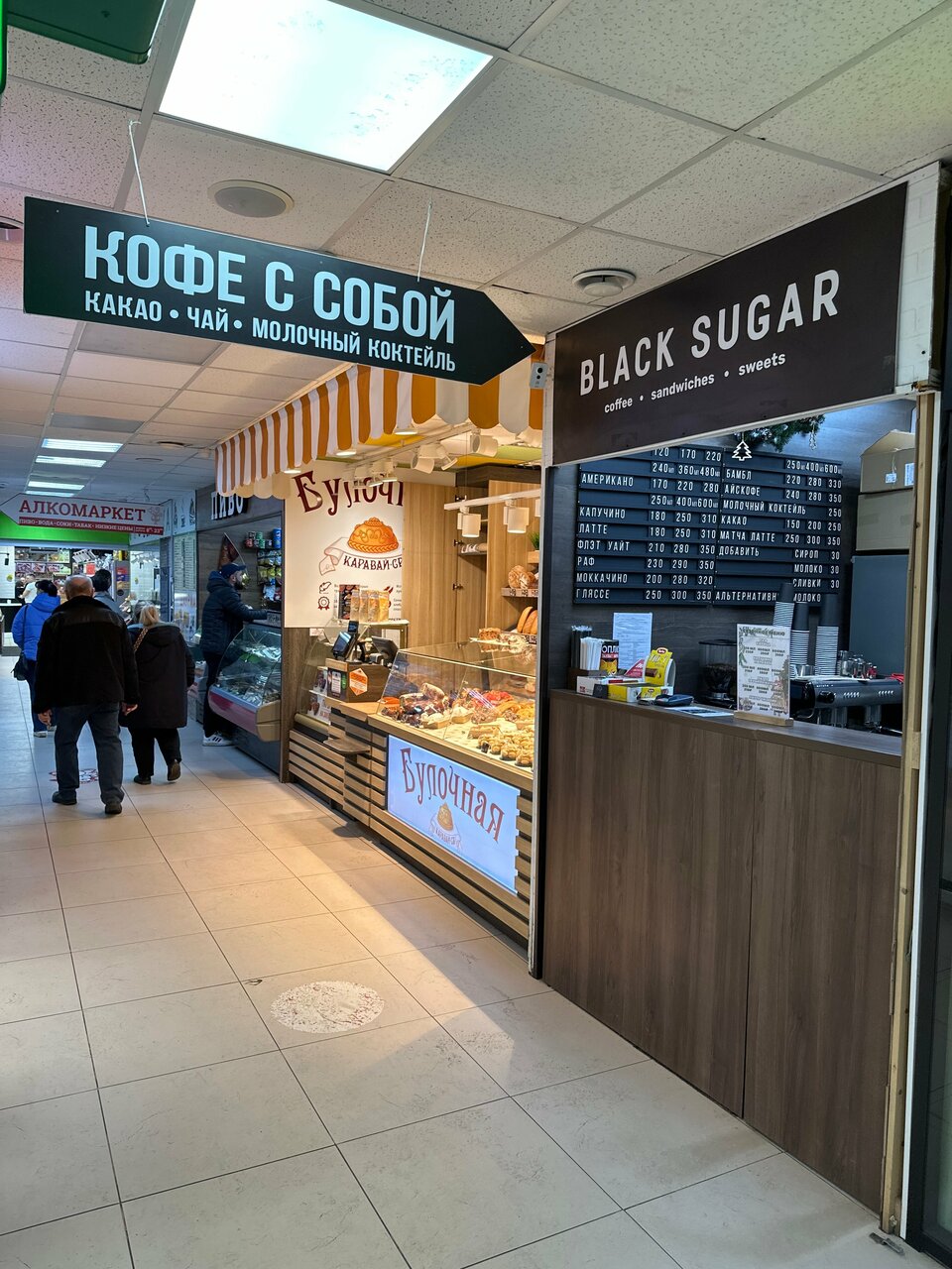 Зелёная стрелка КОФЕ С СОБОЙ и чёрная панель BLACK SUGAR над одной стойкой